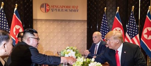 Kim and Trump shake hands across a table at the Singapore Summit (Image courtesy - Dan Scavino Jr., Wikimedia Commons)