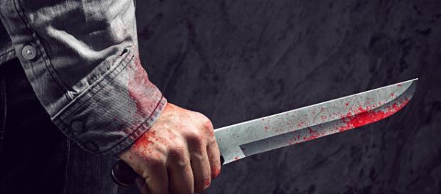foto di una mano che impugna un coltello foto di una mano che impugna un coltello