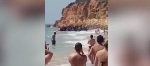 Barca carica di migranti arriva sulla costa spagnola in mezzo ai turisti di un resort di lusso. (Ph. Youtube)