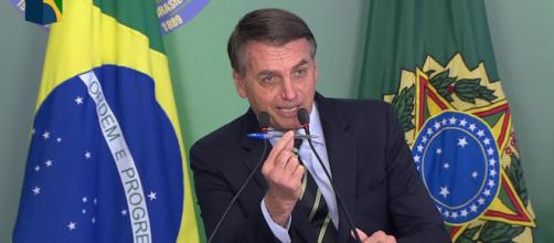 Bolsonaro mostrando a caneta que utilizou para assinar o decreto. (Reprodução / NBR)
