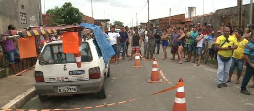 População observa carro em que funcionários da Cemar foram mortos a tiros (Reprodução/TV Mirante)