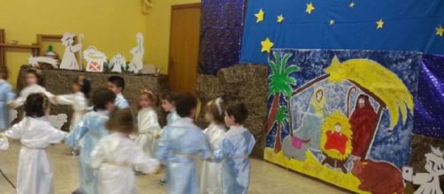 Bambini che danzano e cantano davanti al Presepe