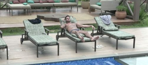 Diego Grossi descansa na área da piscina em "A Fazenda 11" (Reprodução/PlayPlus)