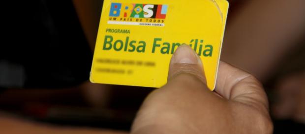 Mulher segura cartão do Bolsa Família (Reprodução) Mulher segura cartão do Bolsa Família (Reprodução)