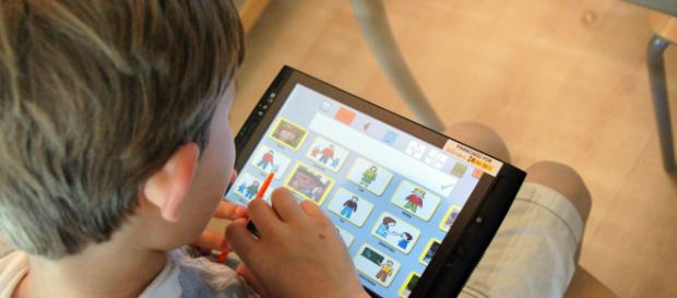 Fotografía de archivo de un niño jugando con una tablet Fotografía de archivo de un niño jugando con una tablet