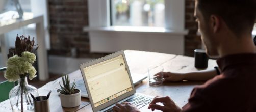 Jeune homme travaillant sur ordinateur dans un openspace