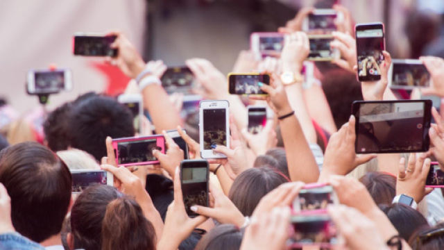 Pubblico con telefoni e tablet durante un concerto