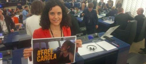 Una parlamentare con un cartello per Carola Rackete