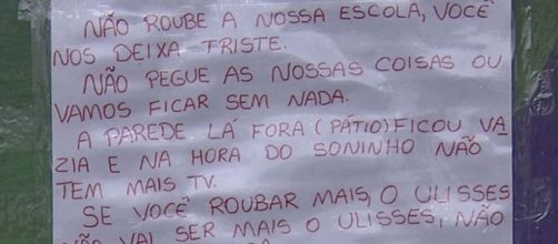 Crianças escrevem cartaz após sequência de furtos em escola. (Reprodução/ TV Globo)