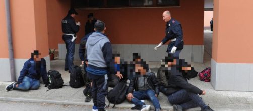 Agenti di polizia con un gruppo di migranti