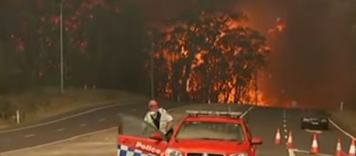 Raging Australian bushfire force residents to water's edge. [Image source/Global News YouTube video]