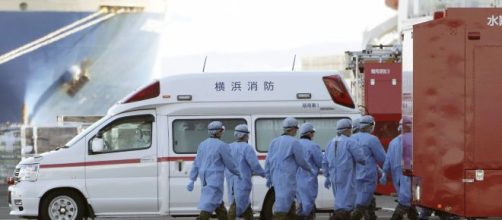 Personale medico mentre sale sulla nave attraccata al largo di Yokohama