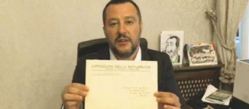 Matteo Salvini che, in passato, mostrava un avviso di garanzia durante una diretta Facebook.