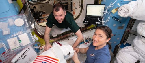 NASA astronauts Nick Hague and Christina Koch work on U.S. spacesuits. [Image source/NASA Wikimedia commons]