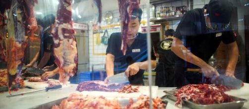 Funcionários de um restaurante, na China, cortando a carne. (Arquivo Blasting News)