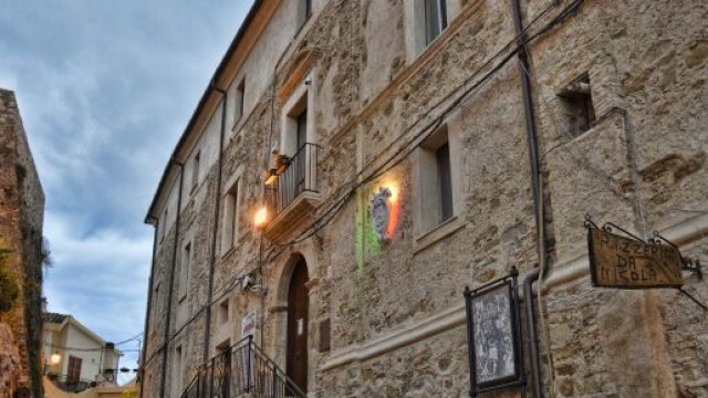 Palazzo Palopoli, sede del municipio, presenta una colorazione simile alle antistanti mura del castello.