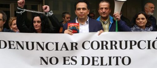 Roberto Macías (en el centro de la foto) sosteniendo una pancarta en una concentración anti-corrupción