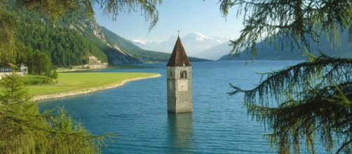 El campanario de la iglesia del siglo XIV de Santa Katharina emerge de las azules aguas del lago en Curon.