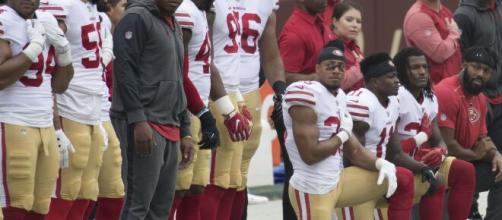 Members of the San Francisco 49ers kneeling for the anthem before a game. [image source: Keith Allison- Wikmedia Commons]