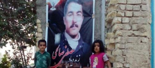 Des orphelins de Mostafa Salehi posent à côté de l'image de leur père exécuté ! Une scène amère et douloureuse.