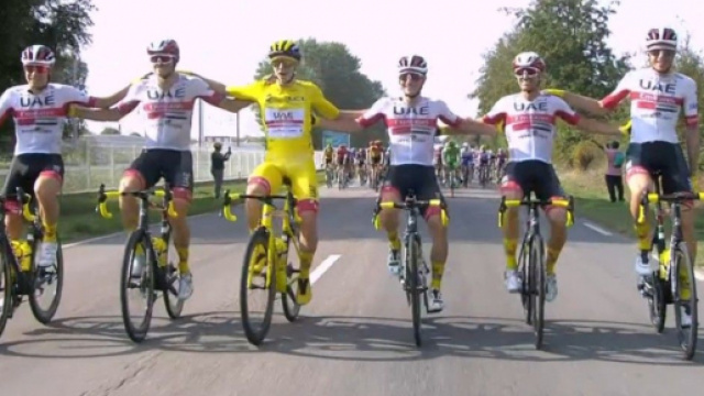 Tadej Pogacar in maglia gialla attorniato dai compagni della UAE Emirates.