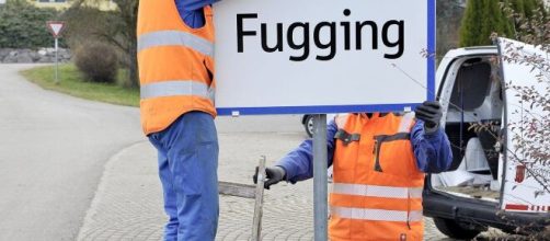 Operai sostituiscono il cartello di Fucking con quello recante il nuovo nome del luogo: Fugging.