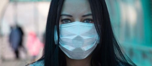 Mujer usando la mascarilla quirúrgica obligatoria Fuente Google Licencia Creative Commons
