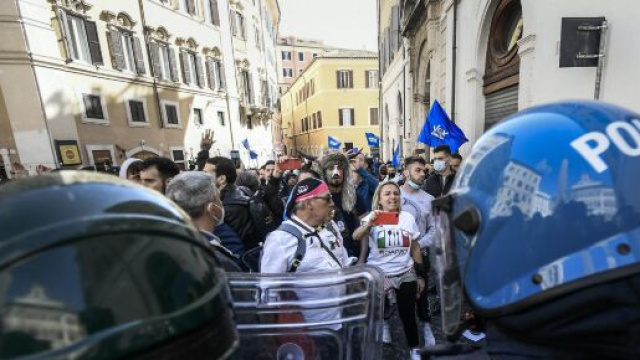Roma, proteste per riaperture, un agente si toglie il casco tra gli applausi della folla.