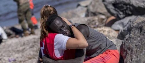 La joven voluntaria de la Cruz Roja, el migrante y un abrazo que es símbolo. (Twitter)