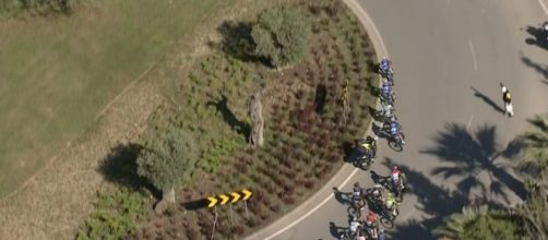 Una moto cerca di superare i corridori in una rotonda alla Volta Algarve.