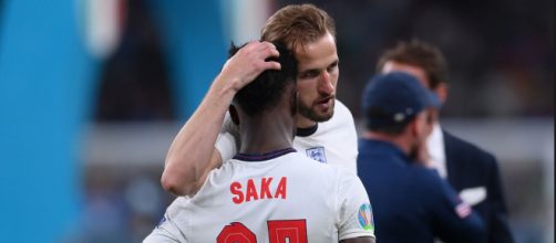 Saka es consolado por Harry Kane. Los jugadores que erraron los penaltis fueron víctima de insultos raciales en redes sociales. (@England)