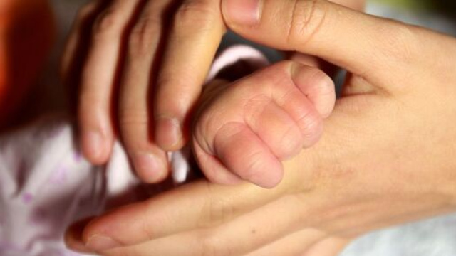 La mano di una madre stringe quella di un neonato (© Pixabay).