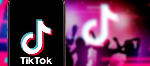 TikTok logo on smartphone and background. [Source: Shutterstock]