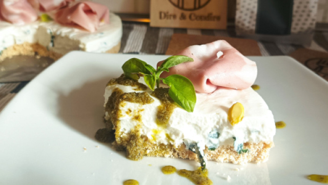 La cheesecake alla ricotta e basilico con guarnizione di mortadella e olio al pesto su base di taralli pugliesi.