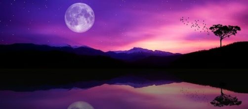 Panorama roseo con luna piena, monti e lago © Pixabay