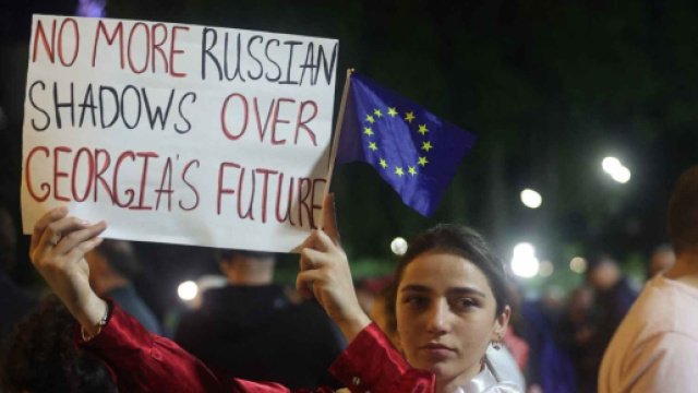 Una manifestante mostra un cartello contro l'influenza russa sulla Georgia