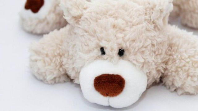 Peluche adagiato sul letto bianco &copy; Pixabay