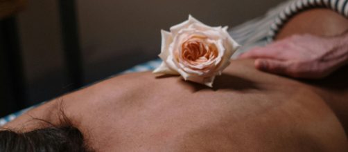 Una donna durante un massaggio con una rosa © Pexels.com