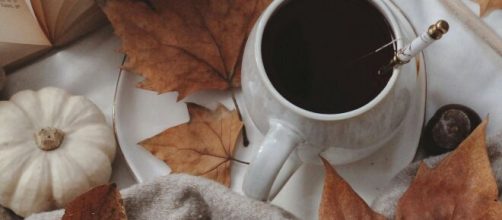 Tazza con caffè, foglie secche e zucca