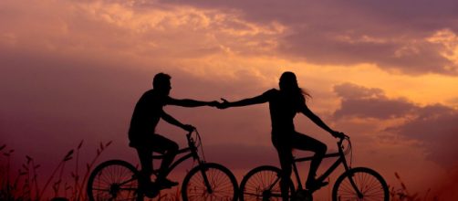 Coppia in bicicletta con tramonto - © Pixabay