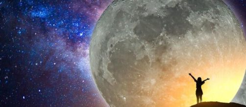 Figura che allarga le braccia davanti alla luna piena © Pixabay