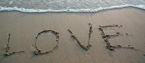 La riva di una spiaggia con la scritta 'love' © Pexels.