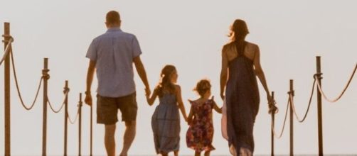 Famiglia che cammina su una spiaggia © Pixabay.