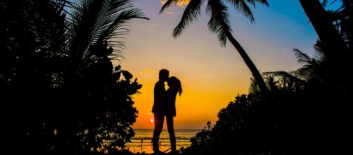 Tramonto con due innamorati in spiaggia - © Pexels.