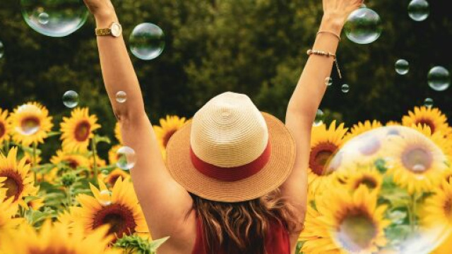 Una ragazza in un campo fiorito (©pexels.com)