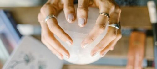 Mani con sfera di cristallo - © Pexels.