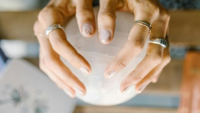 Mani con sfera di cristallo - &copy; Pexels.