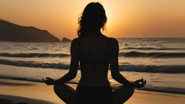 Figura femminile in meditazione sulla spiaggia - © Pixabay.