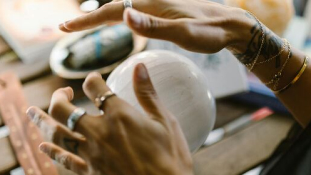 Mani che scrutano sfera di cristallo - © Pexels.