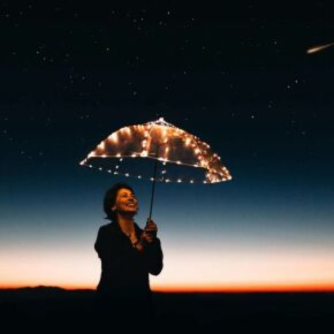 Donna con ombrello in una notte stellata (©pexels.com)